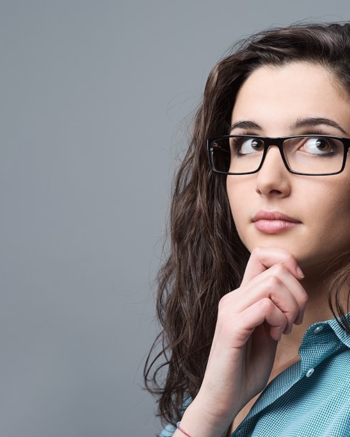 Junge Frau schaut denkend nach oben für Blogartikel So planst du deine Business Story in fünf Schritten