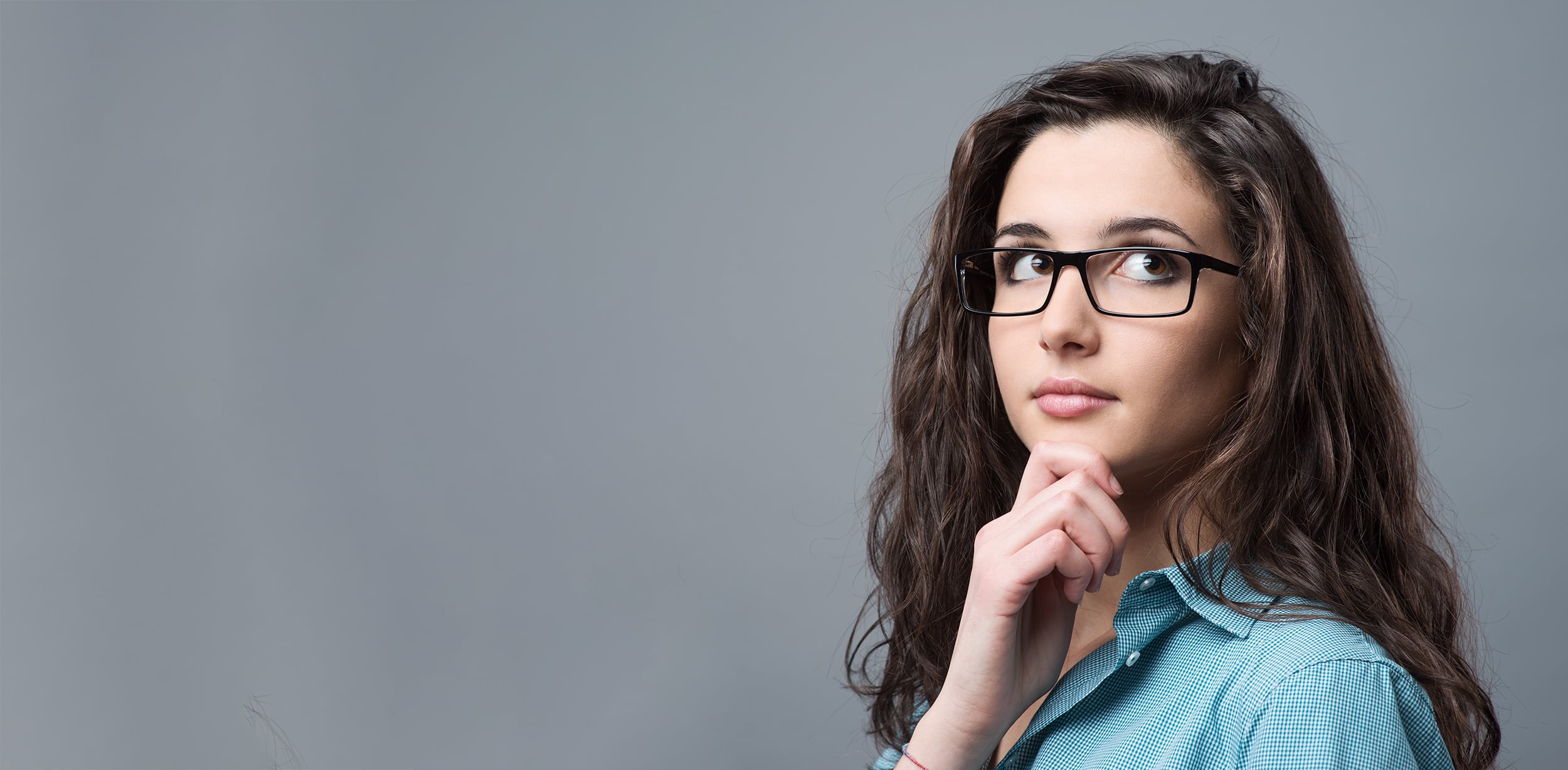 Junge Frau schaut denkend nach oben für Blogartikel So planst du deine Business Story in fünf Schritten
